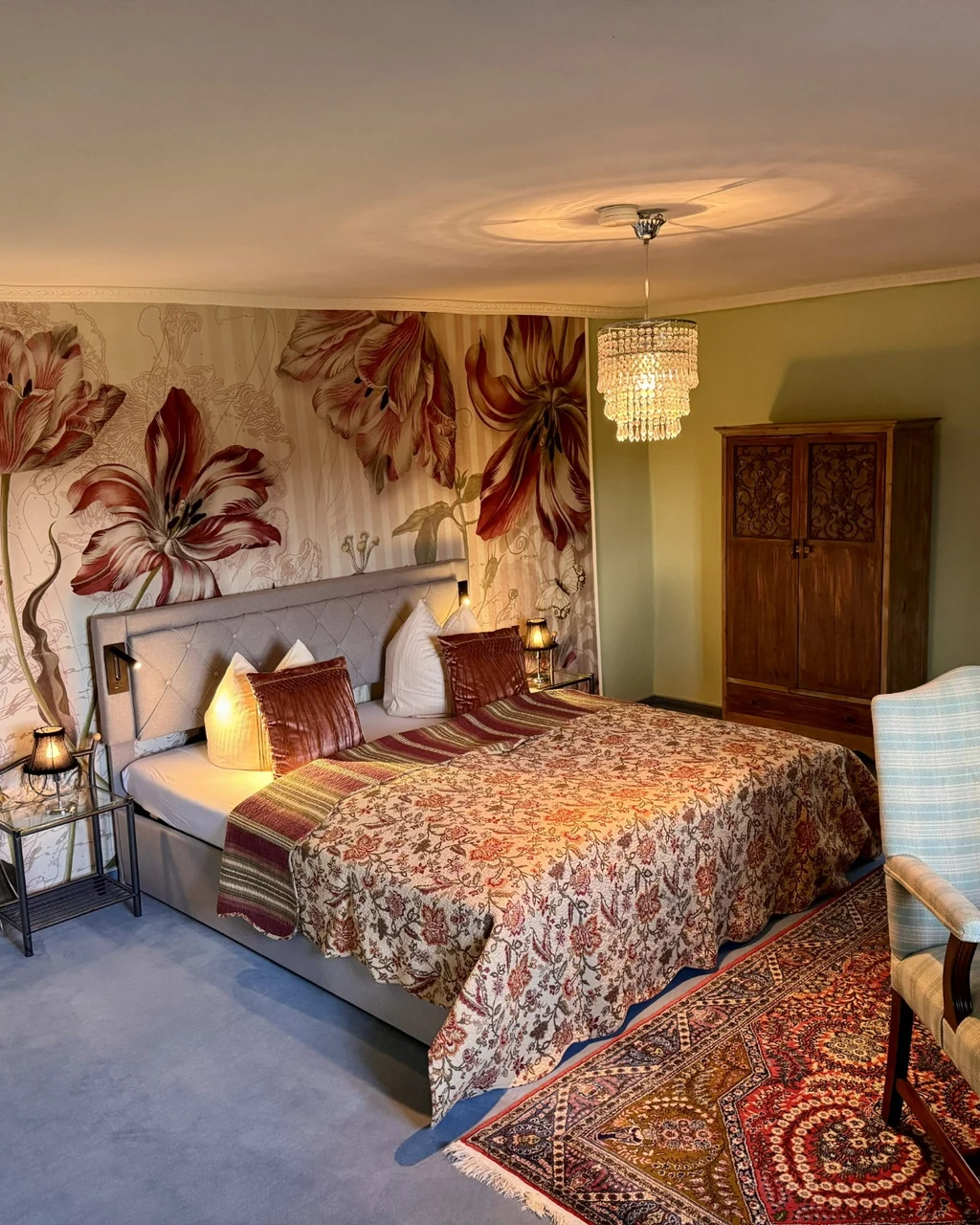 Schlafzimmer mit floraler Wand und schmiedeeisernem Bett