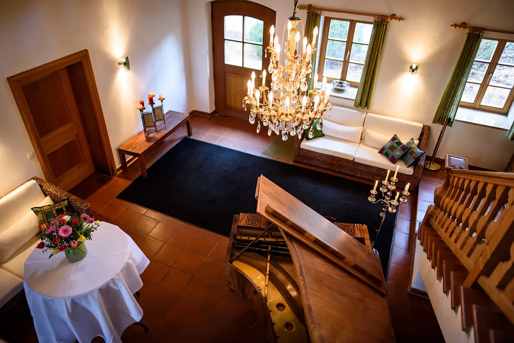 Blick von oben in das Foyer mit Kronleuchter, Flügel und Treppe