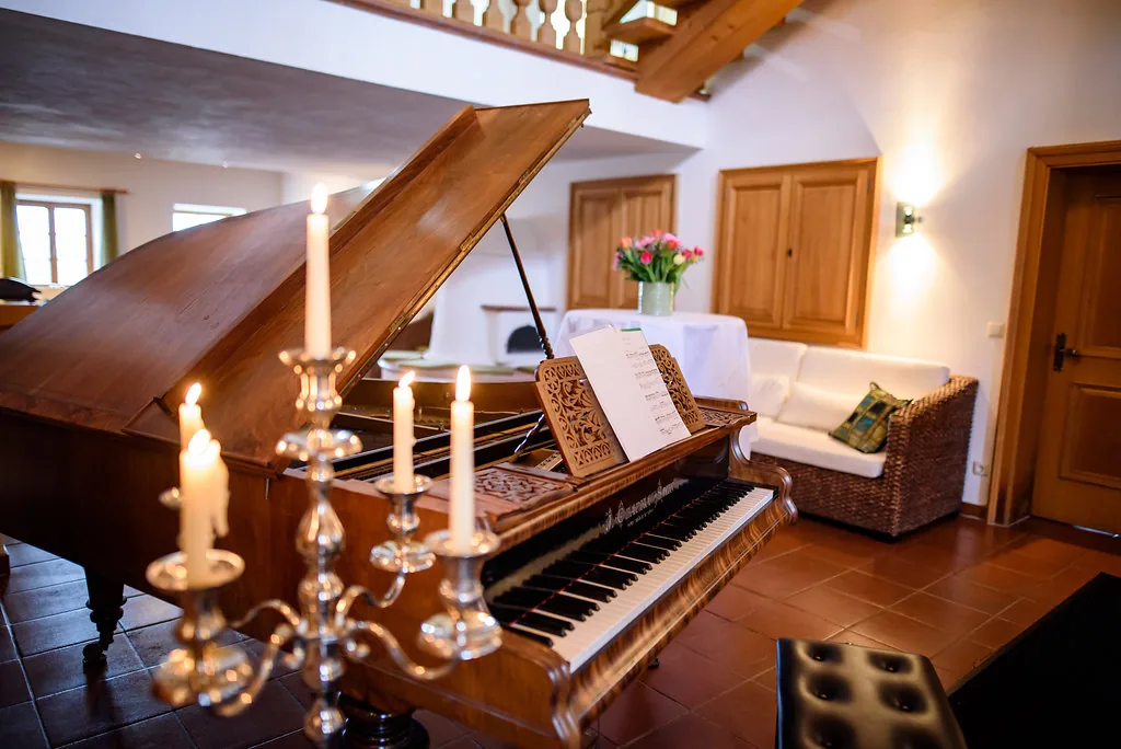 Nahaufnahme des Flügels im Foyer mit Kerzen und wohnlicher Atmosphäre