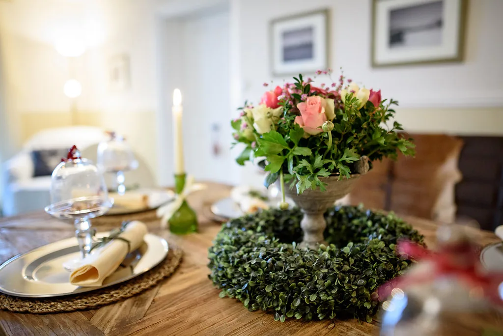 Blumengesteck auf dem gedeckten Tisch