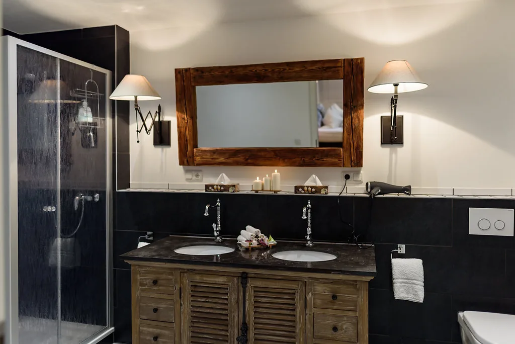 Modernes Badezimmer mit Doppelwaschtisch, großer Dusche und Holzspiegel
