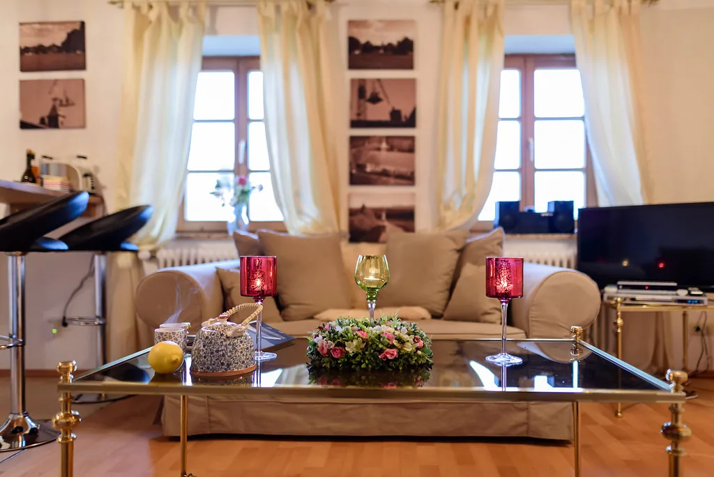 Wohnzimmer mit Glastisch, Sofa und warmem Tageslicht